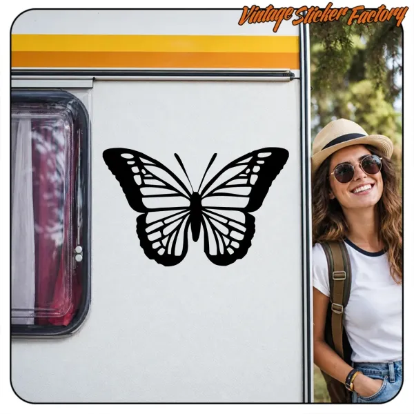 Pegatina de mariposa con alas abiertas aplicada junto a una ventana de furgoneta.