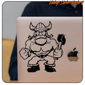 Pegatina de vikingo musculoso con martillo aplicada en un portátil