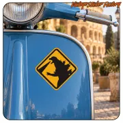 Pegatina amarilla de Godzilla aplicada sobre el frontal de una scooter azul