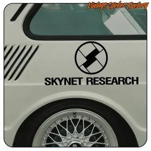 Pegatina negra Skynet Research colocada junto a la rueda trasera de un coche blanco