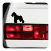 Pegatina negra de schnauzer colocada junto al piloto trasero de un coche blanco