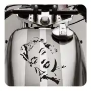 Pegatina de rostro femenino colocada sobre el depósito de una motocicleta